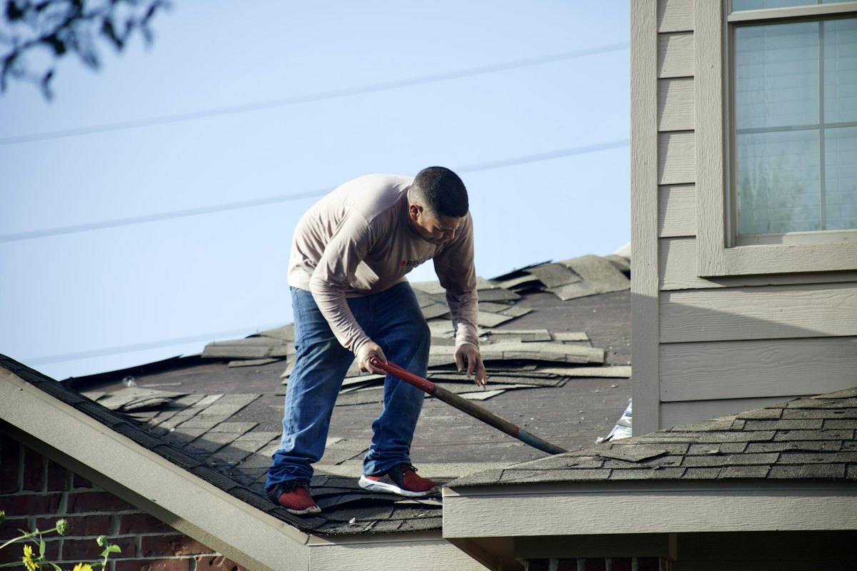 Roofer removing shingles on a residential roof